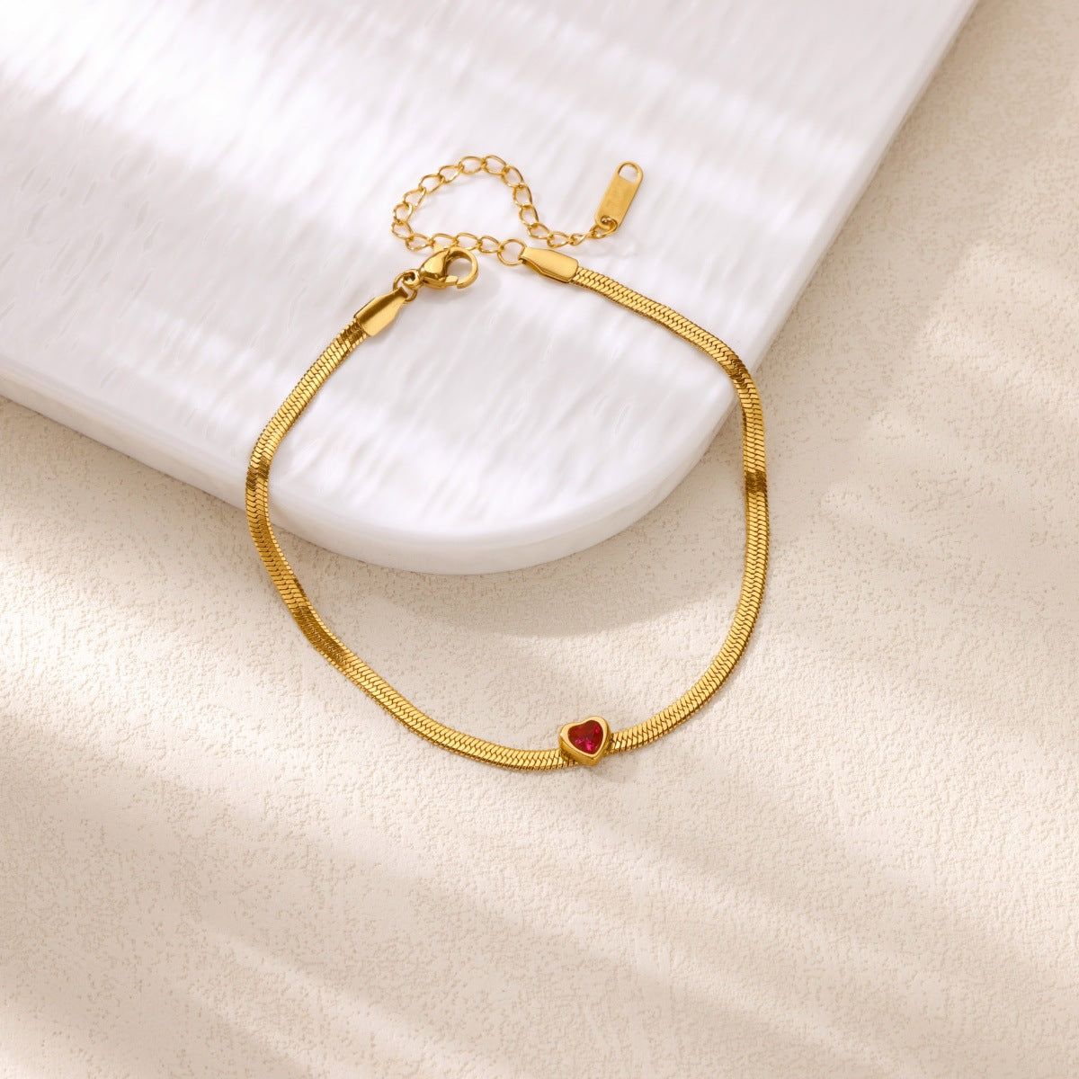 Gold heart charm anklet close-up stone detail