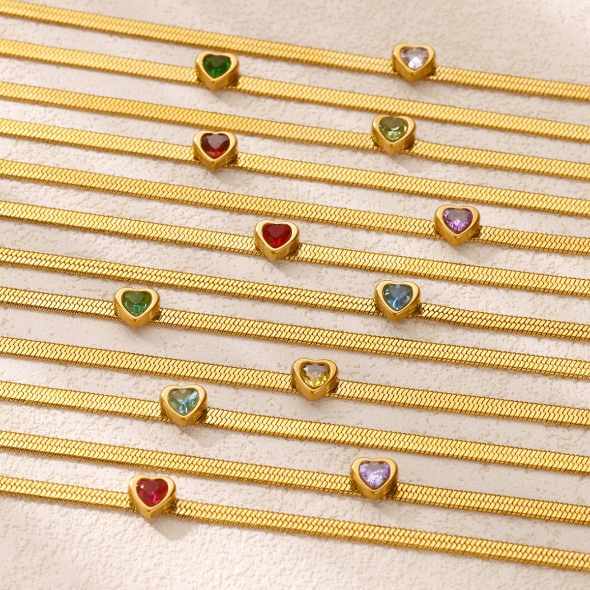 Gold heart charm anklet on white background